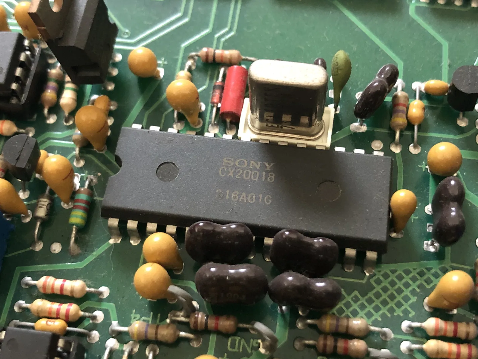 A large chip marked SONY and CX20018, with a metal-can component in a white socket above it.