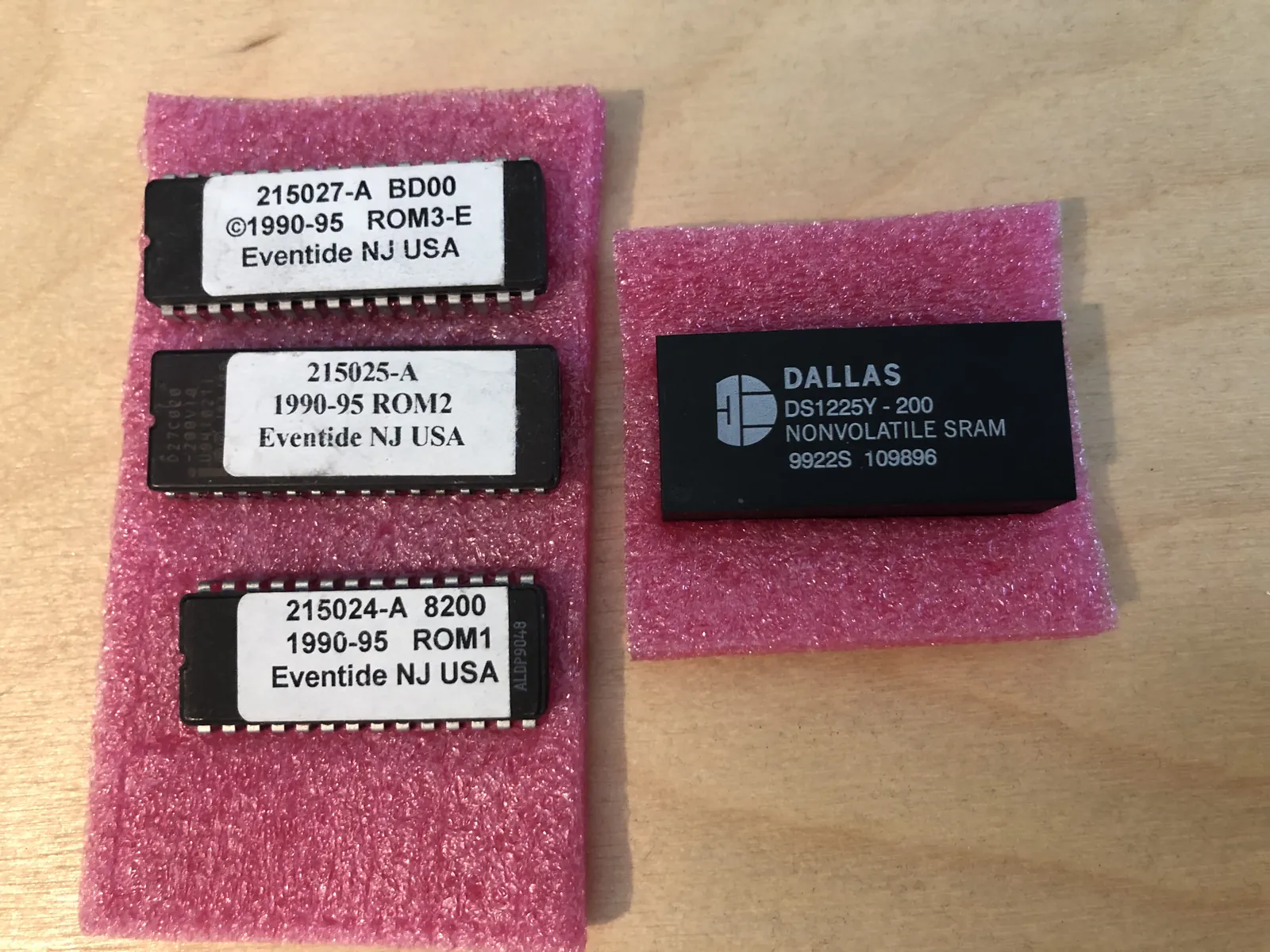Three labeled EPROMs (ROM1, ROM2 and ROM3-E) and a DALLAS DS1225Y NONVOLATILE SRAM chip on pink antistatic foam.