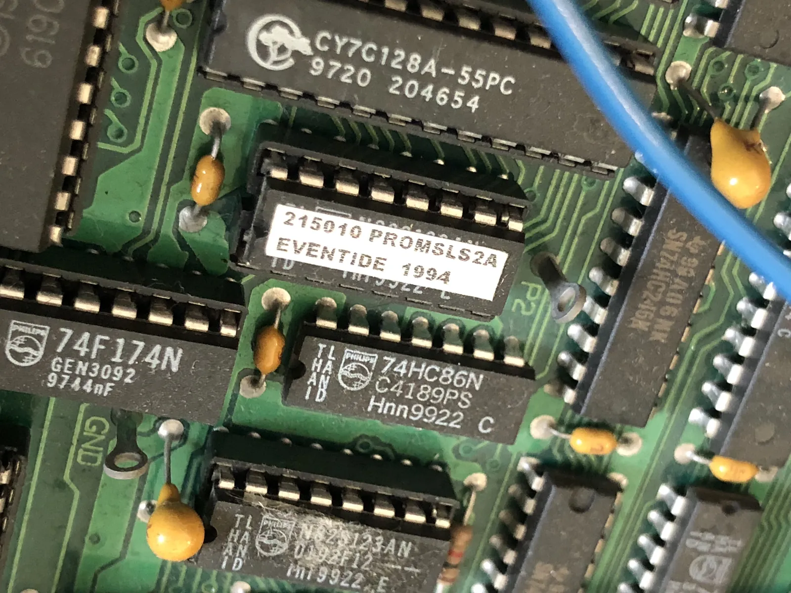 A small chip labeled “215010 PROMSLS2A EVENTIDE 1994,” with a CY7C128A-55PC above and 74HC86N and N82S123AN chips below.